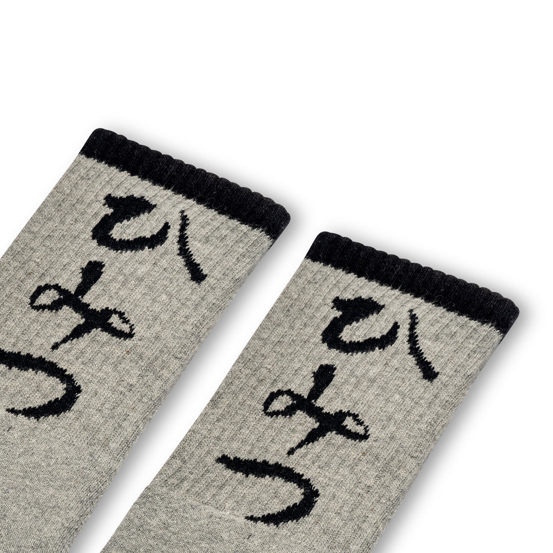 A pair of gray ankle socks with Japanese characters printed on the side, positioned against a white background.
