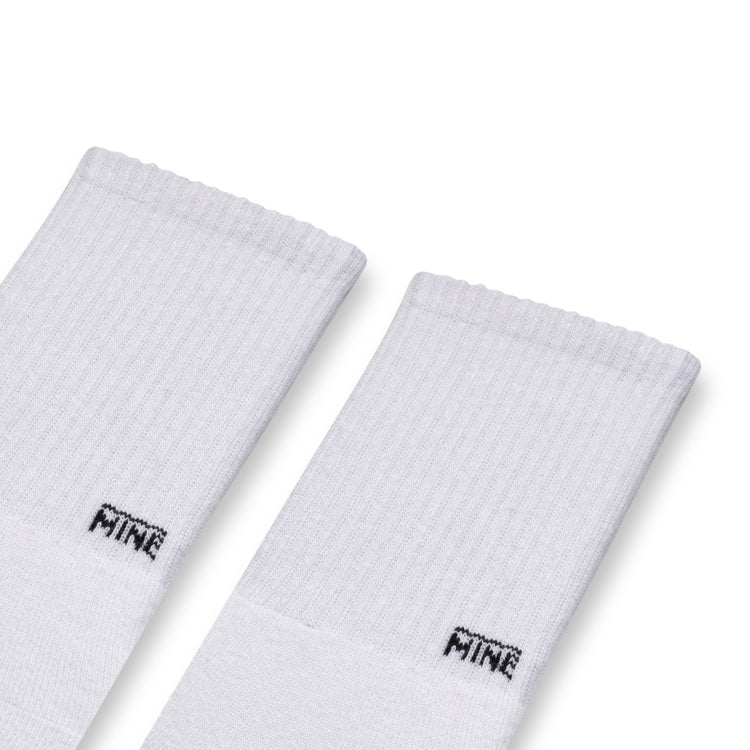 White socks with "MINE" branding on lower ankle