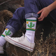 Model in denim jeans wearing Extra Point Cactus socks. 