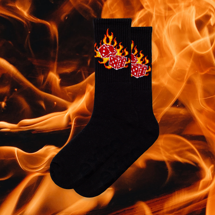 A pair of black socks with a flaming dice design with flaming background