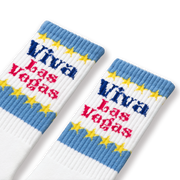 A pair of white socks with blue and yellow 'Viva Las Vegas' text and star patterns.
